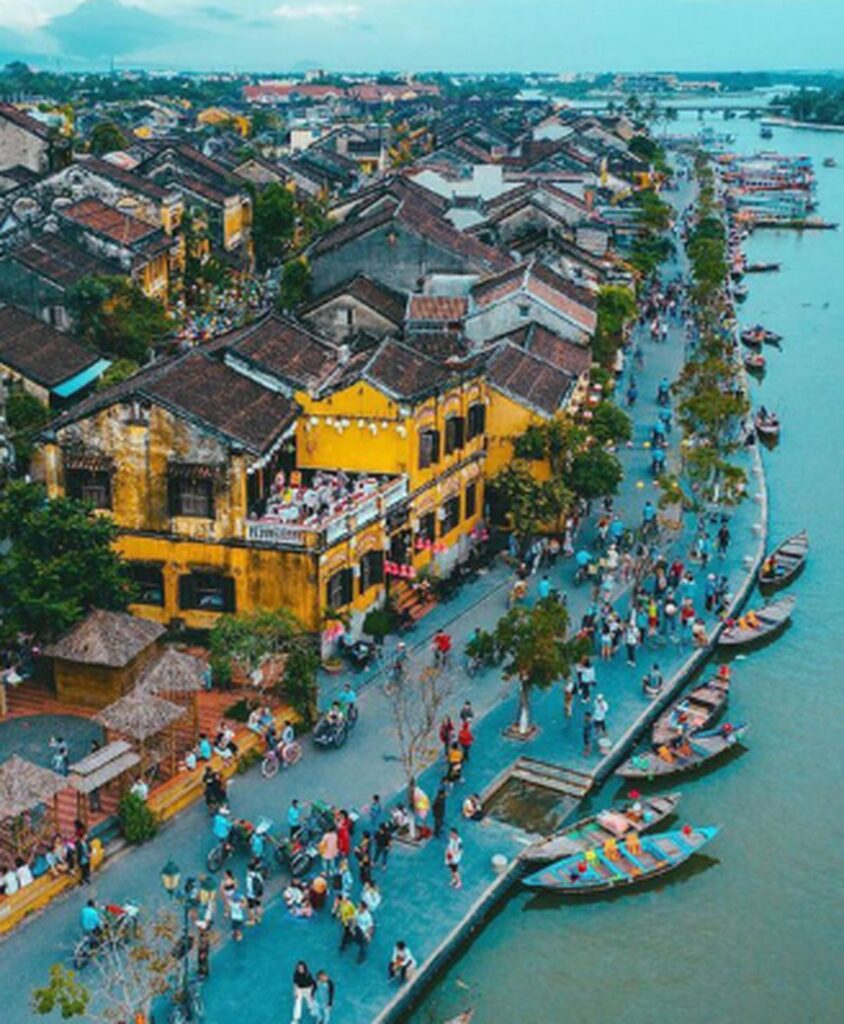 Hoi An Ancient Town Vietnam – Colorful riverside view with boats and tourists, part of Vietnam travel deals 2025